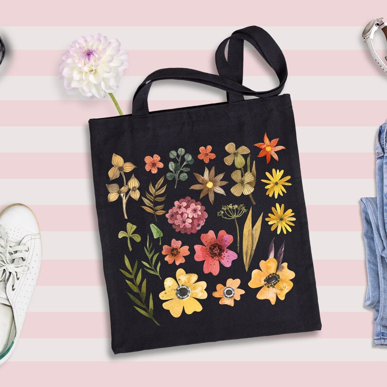May include: A black canvas tote bag with a floral design. The flowers are in shades of yellow, orange, red, pink, and green. The bag has two handles.