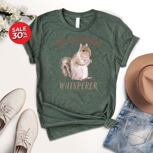 May include: A green t-shirt with a brown squirrel illustration and the text "The Squirrel Whisperer".