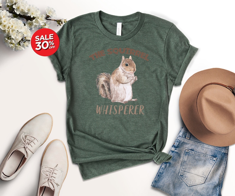 May include: A green t-shirt with a brown squirrel illustration and the text "The Squirrel Whisperer".