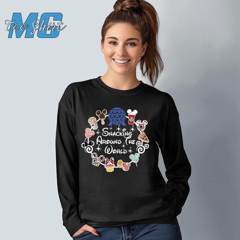 May include: Black long-sleeve shirt with a graphic of a circle of Disney characters and food items. The text "Snacking Around the World" is in the center of the circle.