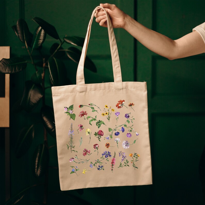Peut inclure: Un sac fourre-tout beige avec un imprim&eacute; floral pr&eacute;sentant une vari&eacute;t&eacute; de fleurs color&eacute;es, notamment roses, violettes, rouges, jaunes et bleues.