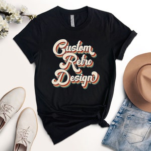 May include: Black t-shirt with a retro-style graphic that says "Custom Retro Design" in colorful, layered letters.