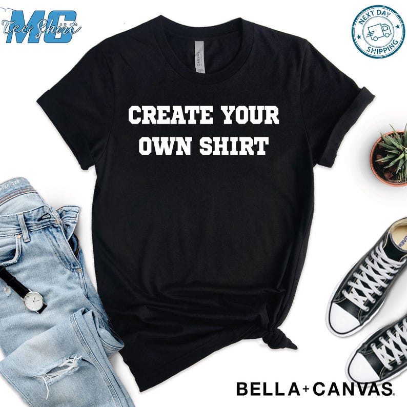 Puede incluir: Camiseta negra con el texto "CREATE YOUR OWN SHIRT" en letras blancas. La camiseta se combina con vaqueros azules, un reloj y zapatillas deportivas blancas y negras. Tambi&eacute;n se ve una peque&ntilde;a planta en maceta.