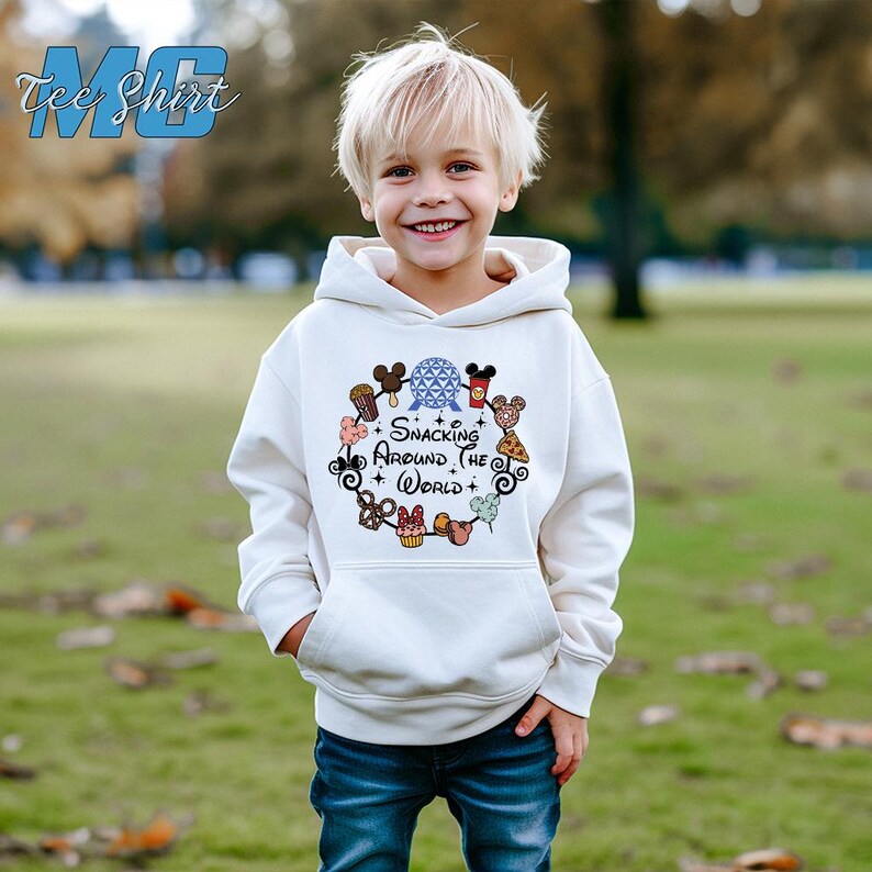 May include: White hoodie with a colorful graphic of Disney characters and snacks. The graphic says "Snacking Around the World".