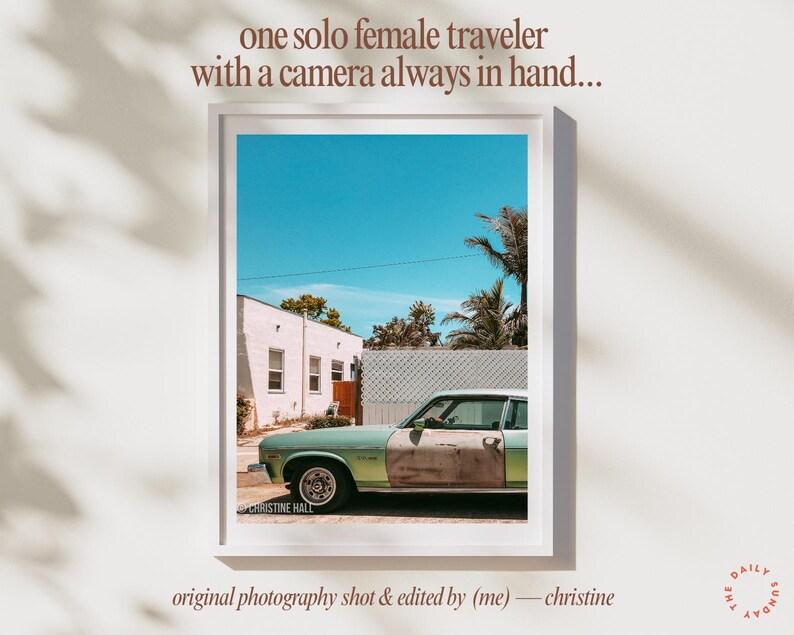May include: A vintage green car parked in front of a white building with a blue sky and palm trees in the background. The car has rust on the side and the text "CHRISTINE HALL" is visible on the bottom left corner of the image.