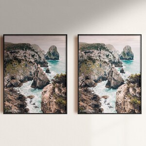May include: Two framed photographs of a rocky coastline with turquoise water crashing against the rocks. The photos are hung on a white wall.