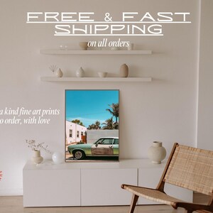 May include: A framed print of a vintage green car parked in front of a building with a blue sky and palm trees in the background. The text "FREE & FAST SHIPPING on all orders" is above the print. The text "one of a kind fine art prints made to order, with love" is below the print. The text "THE DAILY SUNDA" is in a circle in the lower left corner of the image.