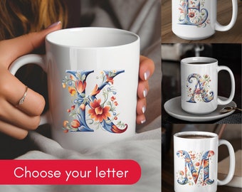 Könnte beinhalten: Weiße Keramikbecher mit floralem Design und einem Buchstaben in der Mitte. Die Buchstaben sind E, A, K und M. Wählen Sie Ihren Buchstaben.