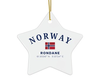 May include: A white star-shaped ornament with the word "NORWAY" in navy blue, a Norwegian flag, and "RONDANE" with coordinates. A gold string is attached for hanging.