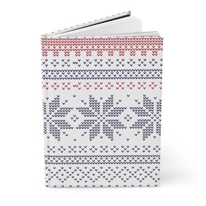Pu&ograve; includere: Un diario bianco con un motivo a maglia blu e rosso sulla copertina. Il motivo presenta fiocchi di neve e strisce.