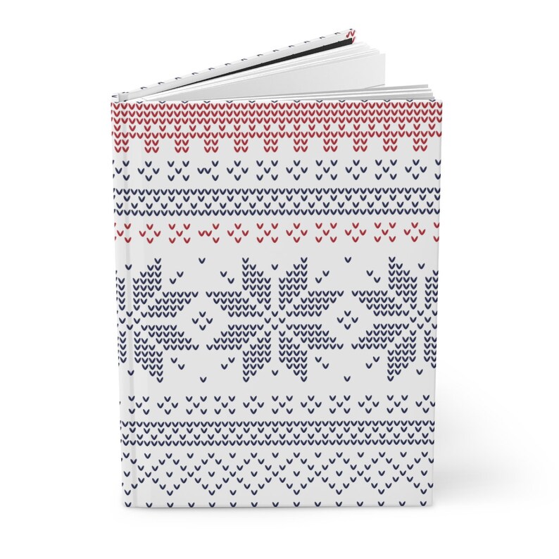 Pu&ograve; includere: Un diario bianco con un motivo a maglia blu e rosso sulla copertina. Il motivo presenta fiocchi di neve e strisce.