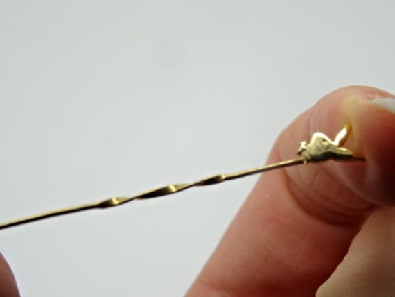 A 9ct Yellow Gold Tie Pin top of twist form having a Playboy Bunny finial to top.