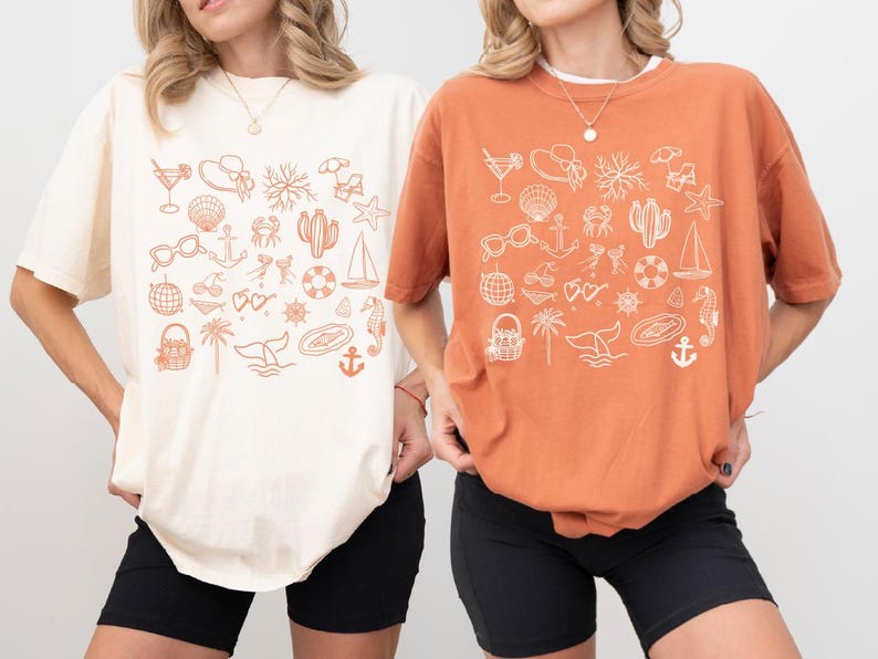 Two women wearing t-shirts with various beach and ocean-themed illustrations.