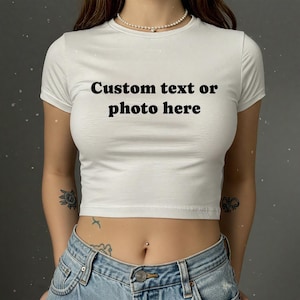 May include: White crop top with short sleeves and the text "Custom text or photo here" printed in black.