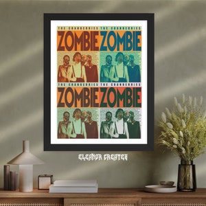 May include: A black and white framed poster with a colourful design. The poster features the text "The Cranberries" and "Zombie Zombie" repeated twice. The poster has a retro, vintage aesthetic.