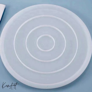 Pu&ograve; includere: Stampo in silicone bianco con tre cerchi concentrici, perfetto per creare sottobicchieri in resina o altri oggetti artigianali.