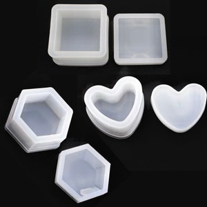 May include: Set of five silicone moulds for making resin jewellery boxes. The moulds are in the shapes of a square, hexagon, heart, and two different heart shapes.