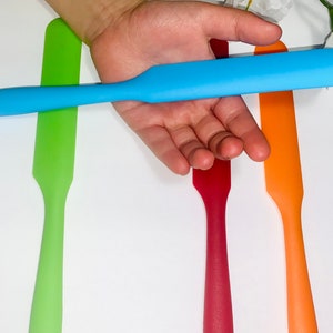 Puede incluir: Cuatro esp&aacute;tulas de silicona en diferentes colores: verde, azul, rojo y naranja. Las esp&aacute;tulas son todas del mismo tama&ntilde;o y forma, con una punta redondeada y un mango recto.