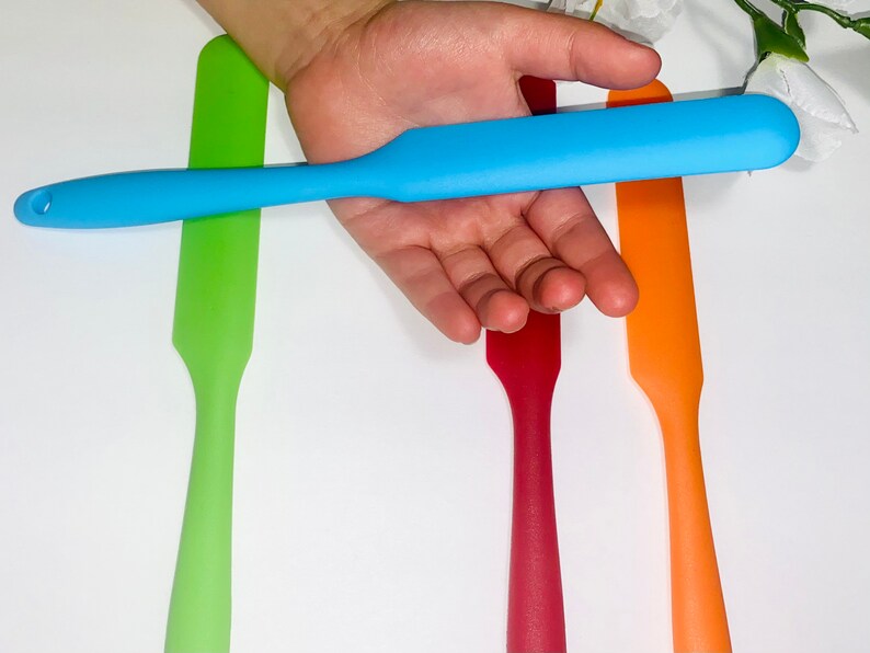 Puede incluir: Cuatro esp&aacute;tulas de silicona en diferentes colores: verde, azul, rojo y naranja. Las esp&aacute;tulas son todas del mismo tama&ntilde;o y forma, con una punta redondeada y un mango recto.