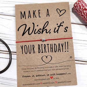 May include: Red string bracelet with a silver heart charm and a card that says "Make a Wish, it's Your Birthday!" Close your eyes, tie this string and make a wish, when the string breaks in two, it's believed that your wish will become true! Dream it, believe, it will happen! (TM) Handcrafted with in USA MakeaWishXO.com MAWXO.com SparkleXO.com