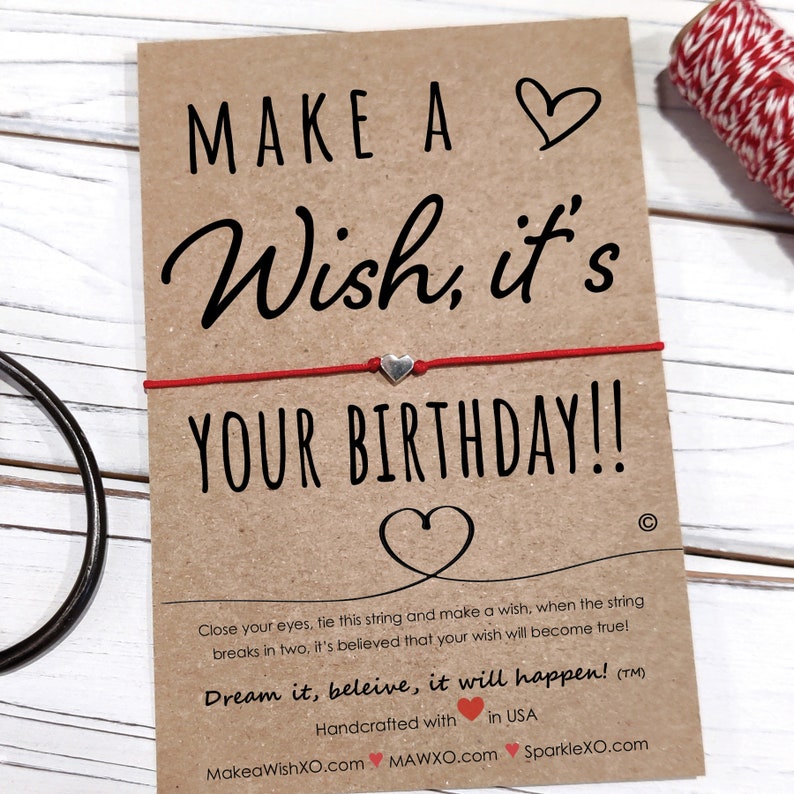 May include: Red string bracelet with a silver heart charm and a card that says "Make a Wish, it's Your Birthday!" Close your eyes, tie this string and make a wish, when the string breaks in two, it's believed that your wish will become true! Dream it, believe, it will happen! (TM) Handcrafted with in USA MakeaWishXO.com MAWXO.com SparkleXO.com