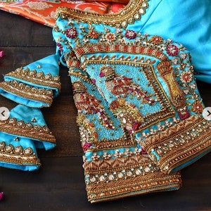 Light blue Maggam blouse with different shades of Antique Zardozi, peacock motifs,Knot work,sequin and stones work