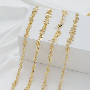 Könnte beinhalten: Vier goldene Ketten mit verschiedenen Arten von dekorativen Gliedern. Die Ketten hängen vor einem weißen Hintergrund.