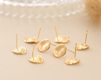 May include: Gold-toned earring findings with a textured, slightly oval-shaped base and a post for attaching earrings.