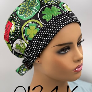 Puede incluir: Un gorro de quir&oacute;fano negro y verde con un ribete de lunares negros y blancos. El gorro tiene un patr&oacute;n de tr&eacute;bol de cuatro hojas y el texto "0134 K" est&aacute; escrito debajo del gorro.