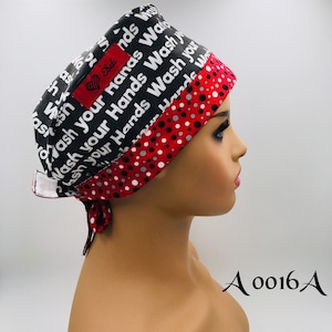 May include: A black and red scrub hat with a white polka dot pattern. The hat has a white label with the text "Wash your Hands" repeated multiple times and a small heart with the word "Ebele" on it. The hat is tied at the back with a red ribbon. The text "A 0016A" is visible in the lower right corner of the image.