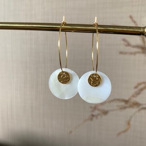 May include: A pair of gold hoop earrings with white shell and gold disc accents.