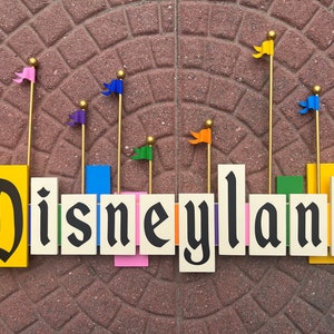 Letrero vintage de entrada a Disneyland con banderas