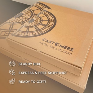 May include: Cardboard boxes stacked, featuring a Big Ben clock face design. The boxes are labeled "CAST MERE METAL WALL CLOCKS". The boxes are sturdy and ready to gift.