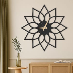 May include: Black metal wall clock with a flower-shaped design. The clock has gold-colored hands and a black face.