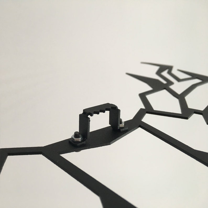 May include: Black metal wall decor with a geometric design. The decor has a hanging hook on the back.