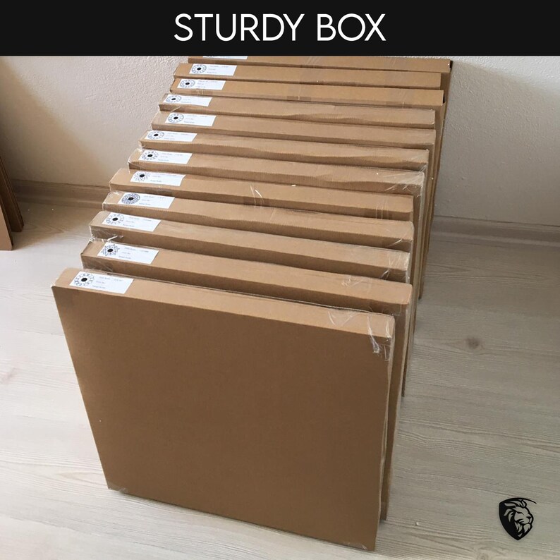 May include: A stack of brown cardboard boxes, each with a white label and a small black circle in the center. The boxes are stacked neatly on a wooden floor. The text "STURDY BOX" is visible at the top of the image.
