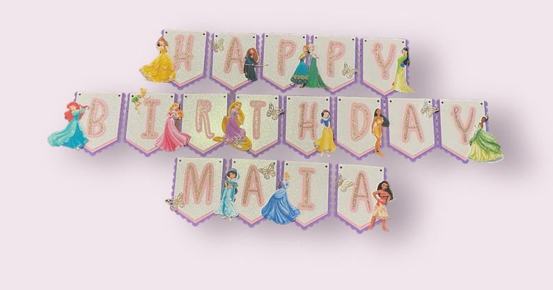 May include: A pink and white banner with the words "Happy Birthday Maia" decorated with Disney Princess characters. Each letter is adorned with a different princess, including Ariel, Belle, Cinderella, Snow White, and more.