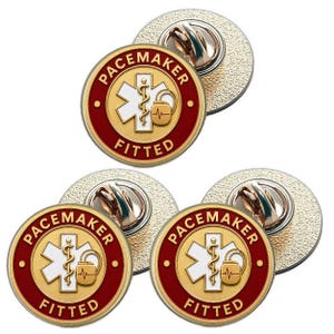 May include: A set of six round pins with a gold border and a red outer ring. The pins feature the text "PACEMAKER FITTED" and a medical symbol with a lock and a heartbeat line.