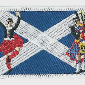 May include: Embroidered patch showing the Scottish flag, a blue background with a white saltire. The patch features a Scottish dancer in a red kilt and a bagpiper in traditional dress. The patch has a white border.
