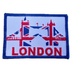 以下が含まれることがあります： ロンドンのタワーブリッジを描いた刺繍パッチ。赤、白、青のアクセント。下部には赤で「LONDON」の文字が刺繍されています。パッチは青い縁取りがされています。