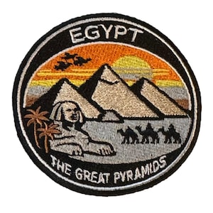 May include: Embroidered patch depicting an Egyptian landscape. The design includes the word "EGYPT", pyramids, a sphinx, palm trees, camels, and the text "THE GREAT PYRAMIDS". The patch has a black border.