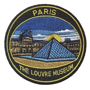 May include: Embroidered patch featuring the Louvre Museum in Paris. The design includes the iconic glass pyramid, the museum building, and the text "PARIS" and "THE LOUVRE MUSEUM" in yellow and white lettering against a black background. The patch has a circular shape.