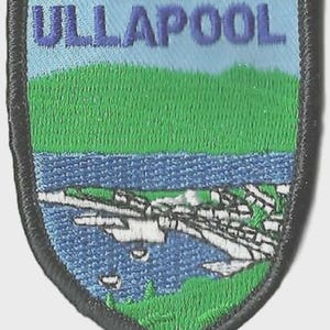 May include: Embroidered patch featuring the word "ULLAPOOL" above a landscape scene. The patch depicts a blue sky, green hills, a blue body of water, and a white and gray town. The patch has a black border.