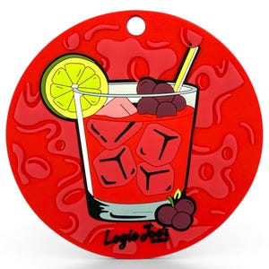 May include: A red, round coaster featuring a cartoon cocktail illustration. The drink has ice cubes, a lime slice, and grapes. The coaster has a hole for hanging and the text "Logic Joe's" at the bottom.