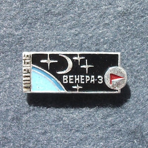 Puede incluir: Un pin rectangular plateado con un fondo negro que presenta una luna creciente, estrellas y el texto cirílico "ВЕНЕРА-3". El pin incluye un diseño azul claro y blanco a la izquierda y una bandera roja en un círculo a la derecha.