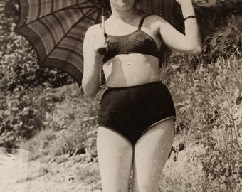Photo vintage belle fille posant en maillot de bain en bikini sous-vêtements parapluie sur la plage