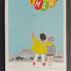 May include: A vintage postcard featuring a cartoon illustration of two children looking up at a string of colorful balloons with the text "1 MAY" in Russian. The children are standing in front of a building with a large dome and other buildings in the background.