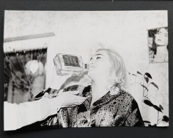 Kobieta pijąca alkohol z butelki. Zdjęcie archiwalne.
