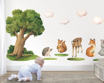May include: A set of woodland animal wall decals featuring a deer, fox, squirrel, hedgehog, and rabbit. The decals are on a white wall with a green tree and clouds.