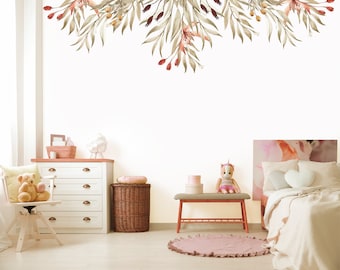 May include: A white dresser with four drawers, a wicker basket, a wooden chair with a teddy bear, a pink rug, a wooden bench, a unicorn doll, and a white bed with a pink headboard and white bedding. The wall behind the furniture is decorated with a garland of green leaves and red berries.